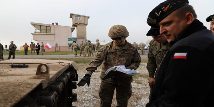 GREYWOLF Trooper, Spc. Bryce Henderson, assigned to Bravo Company, 1st Battalion, 12th Cavalry Regiment, 3rd Armored Brigade Combat Team, 1st Cavalry Division shows Polish soldiers from the 1st Warsaw Brigade the Abrams M1A2 SepV3 main battle tank..