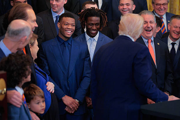 President Donald Trump jokes wth Alijah Martin and Denzel Aberdeen while hosting the 2025 NCAA men's basketball champion Florida Gators to celebrate...