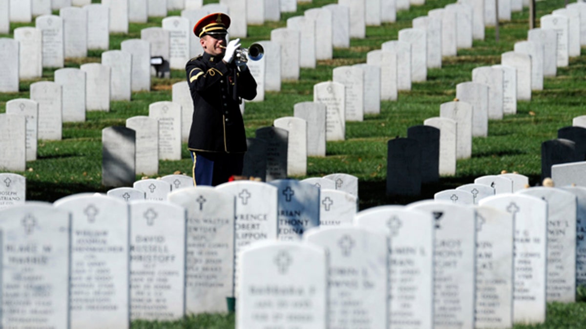 A U.S. Army bugler plays "Taps" among rows of white headstones during a military funeral at Arlington National Cemetery, honoring a fallen service member.