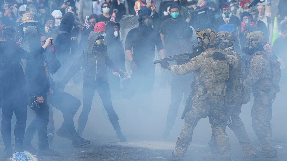 standoff between Border agents and demonstrators as smoke fills air