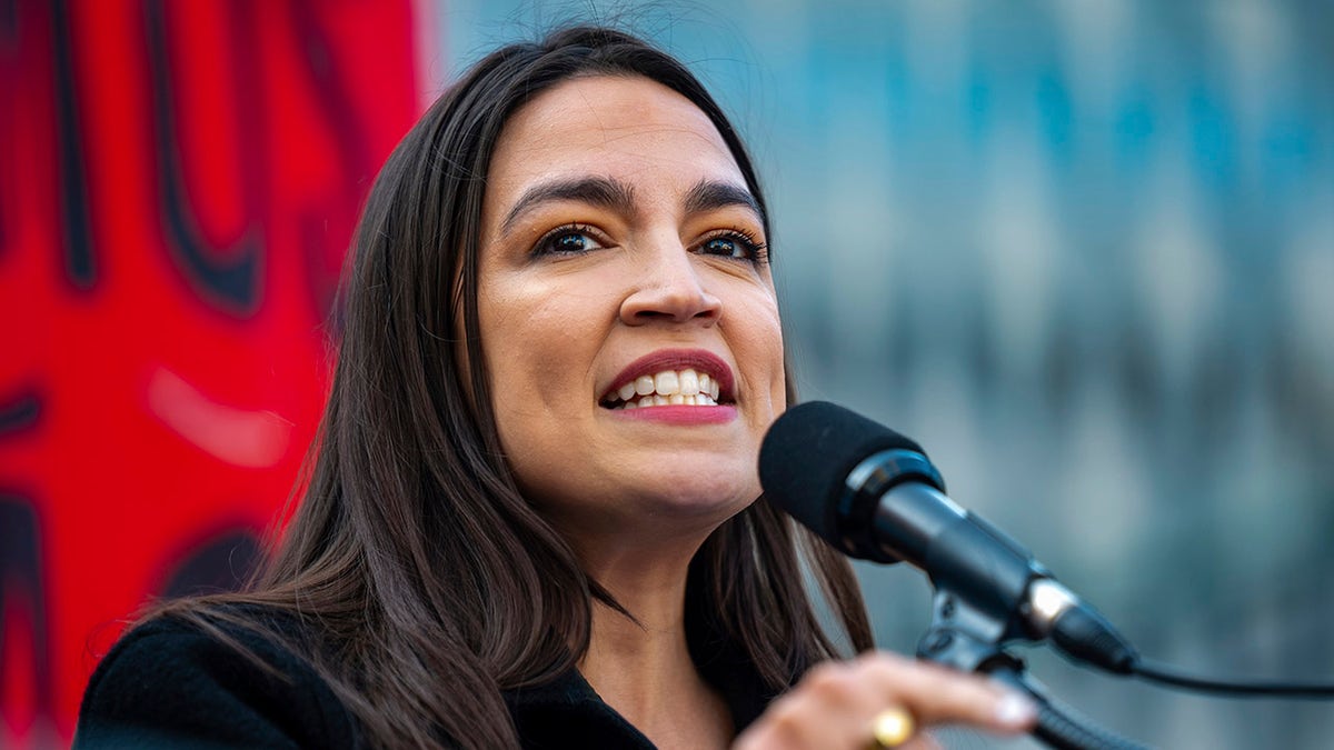 AOC speaking at microphone in New York in May 2025