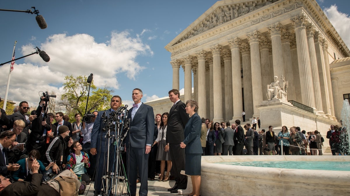 Plaintiffs in the Obergefell v. Hodges case speaks at a press conference outside the U.S. Supreme Court, surrounded by reporters and cameras on a sunny day.