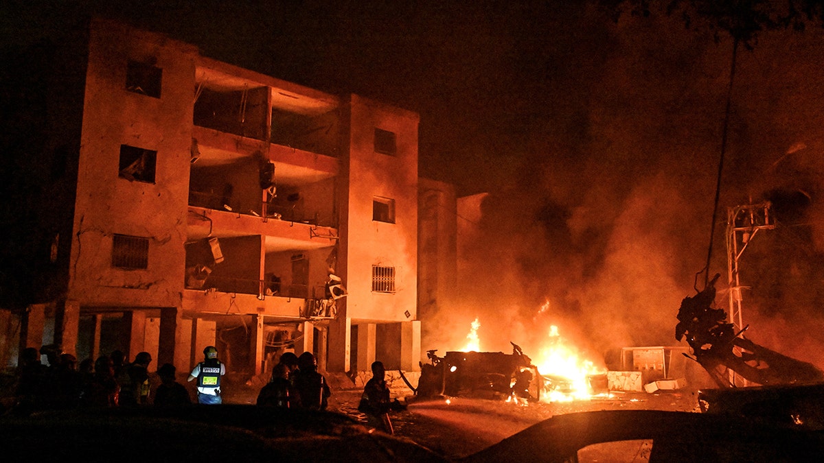 Firefighters and rescue personel work at an impact site following missile attack from Iran on Israel, at Haifa, Israel, June 15, 2025.