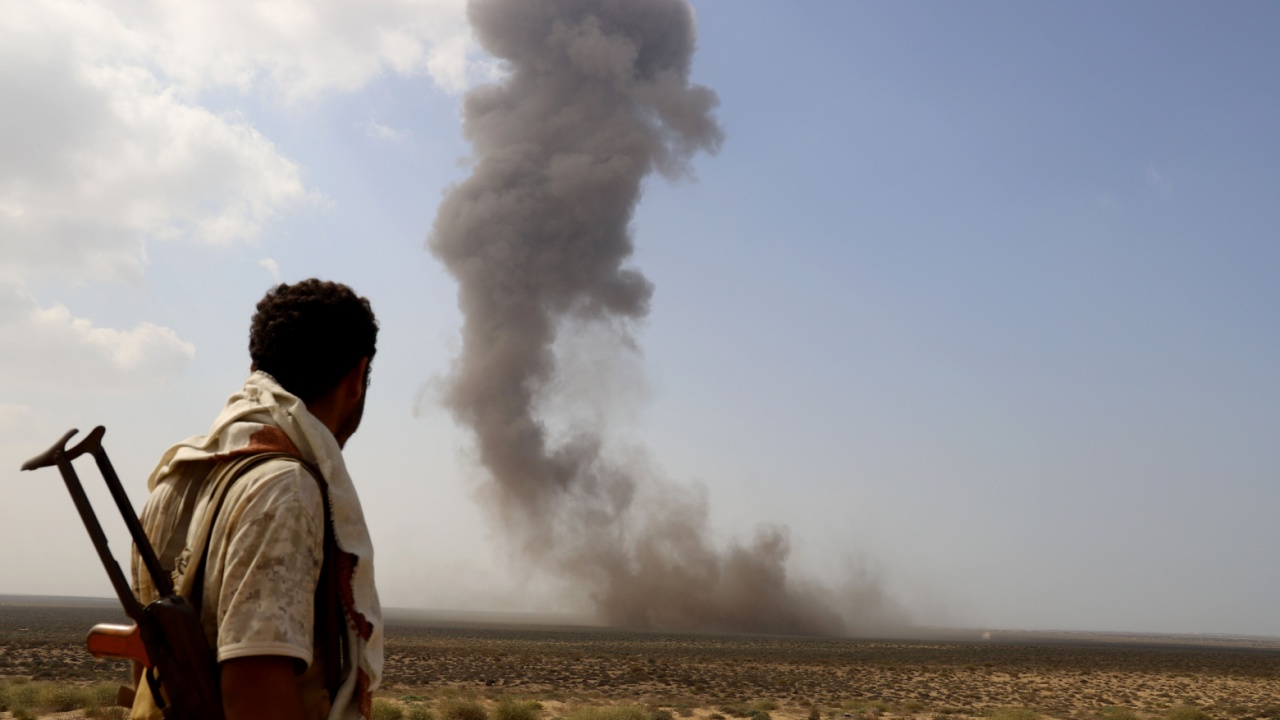 Yemeni fighter looks at Houthi explosion.