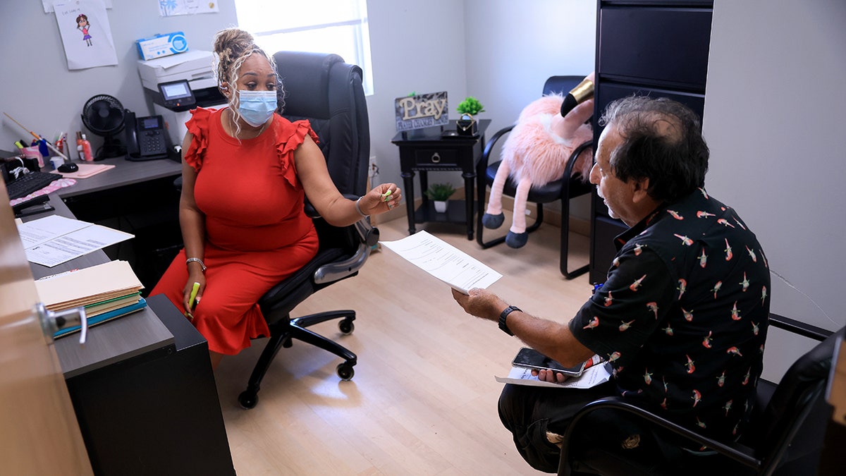 Alicia Lester, case manager and Service Coordinator, helps Henry Pedoff fill out a Medicaid and a food stamps application at the LifeNet4Families center on May 14, 2025 in Lauderhill, Florida.