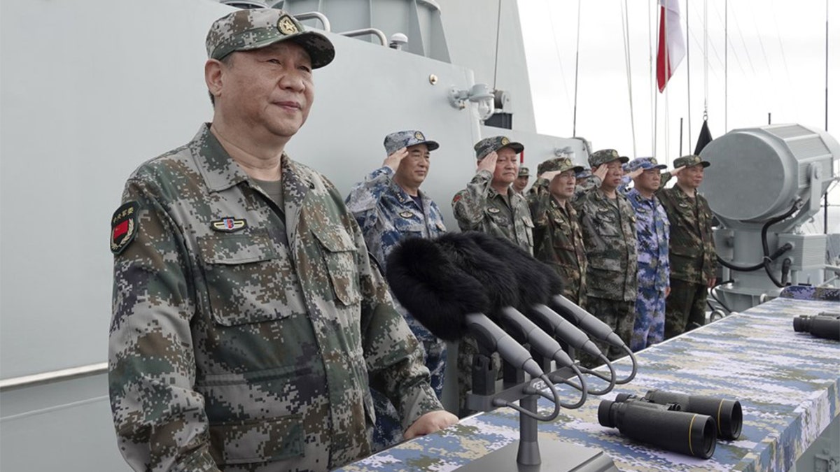 In this April 12, 2018, file photo released by Xinhua News Agency, Chinese President Xi Jinping speaks after reviewing the Chinese People's Liberation Army (PLA) Navy fleet in the South China Se