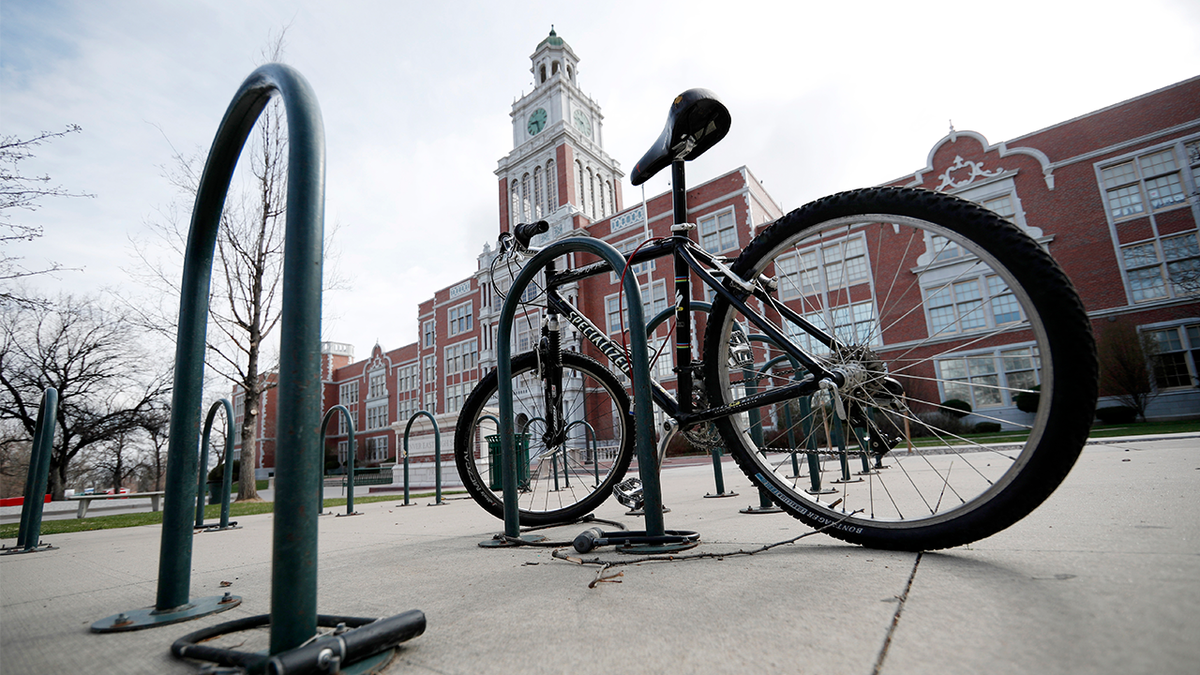 A bicycle stands in the rack outside East High School