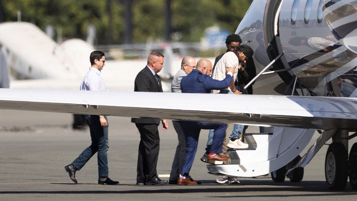 Harjinder Singh is escorted onto an airplane by Florida Lt. Gov. Jay Collins and law enforcement on Thursday, Aug. 21, 2025, in Stockton, Calif.