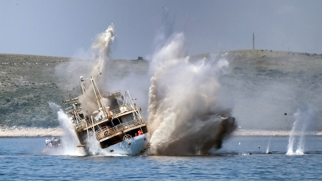 An explosion next to a derelict ship.