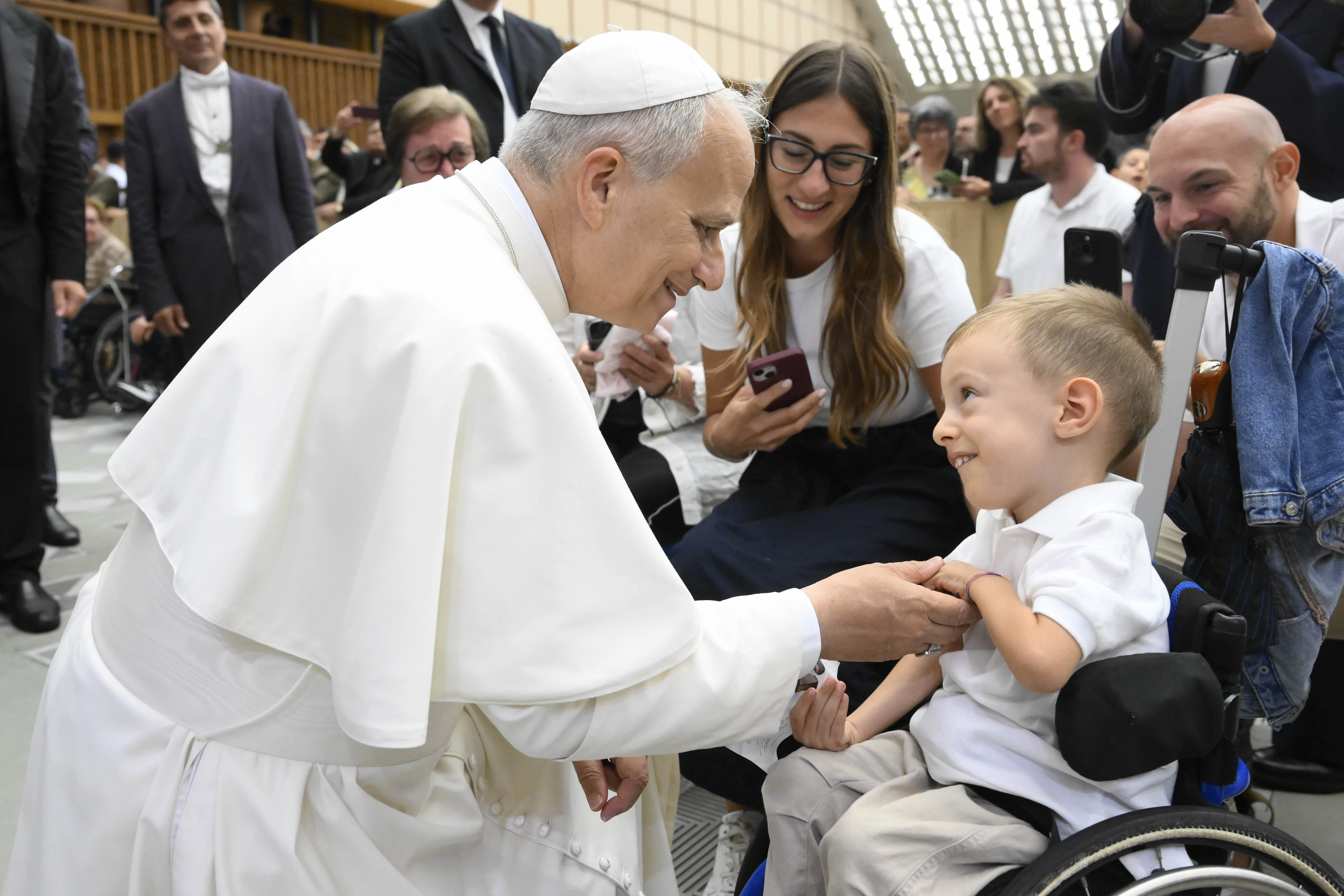 Pope Leo XIV greets newlyweds and sick and disabled people, including a young child in a wheelchair, in the Vatican's Paul VI Hall after the Wednesday general audience on Sept. 10, 2025. Credit: Vatican Media