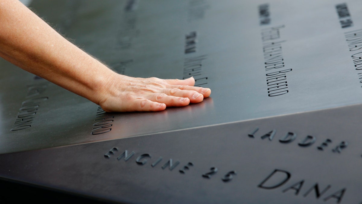 Woman places hand on 9/11 monument