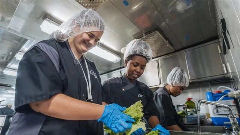 Belmont Abbey College senior nursing student Emma Harris (left) volunteers in the galley aboard the Africa Ship. Credit: Joshua Kiew Wing Chau