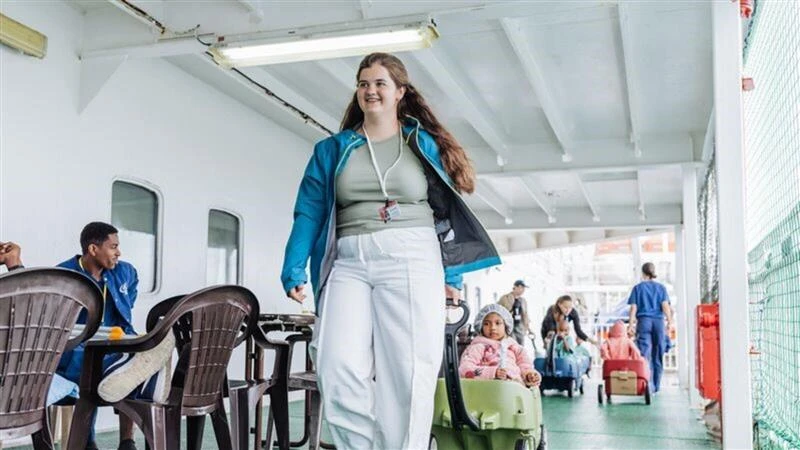 Belmont Abbey College senior nursing student Emma Harris with a patient on the Africa Mercy ship deck during her two-week-long internship with Mercy Ships in summer 2025. Credit: Joshua Kiew Wing Chau