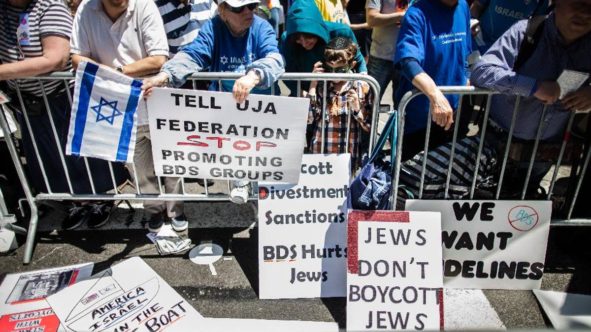FILE - In this Sunday, June 1, 2014 file photo, protesters against the Boycott, Divestment and Sanctions (BDS) movement stand behind a police barricade during the Celebrate Israel Parade in New York. The international boycott movement against Israel over its treatment of the Palestinians has gained some momentum in the U.S. Once a unifying cause for generations of American Jews, Israel is now bitterly dividing Jewish communities. (AP Photo/John Minchillo)