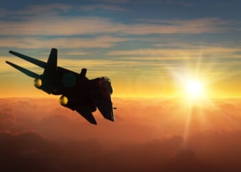 An F-14 Tomcat flying at sunset.