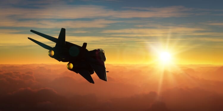 An F-14 Tomcat flying at sunset.