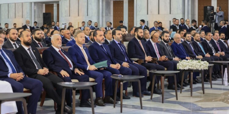 Syrian president Ahmed al-Shara and US Envoy Tom Barrack sit in a meeting.