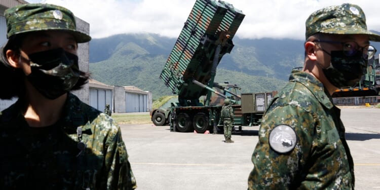 Two Taiwanese soldiers in front of a missile launcher.