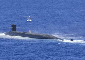 An AS-332 Super Puma assigned to the Lewis and Clark-class dry cargo ship USNS Cesar Chavez (T-AKE 14) delivers supplies to the Ohio-class ballistic missile submarine USS Louisiana (SSBN 743) during a vertical replenishment at sea, June 28, 2024.