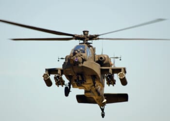 An AH-64 Apache attack helicopter in flight.