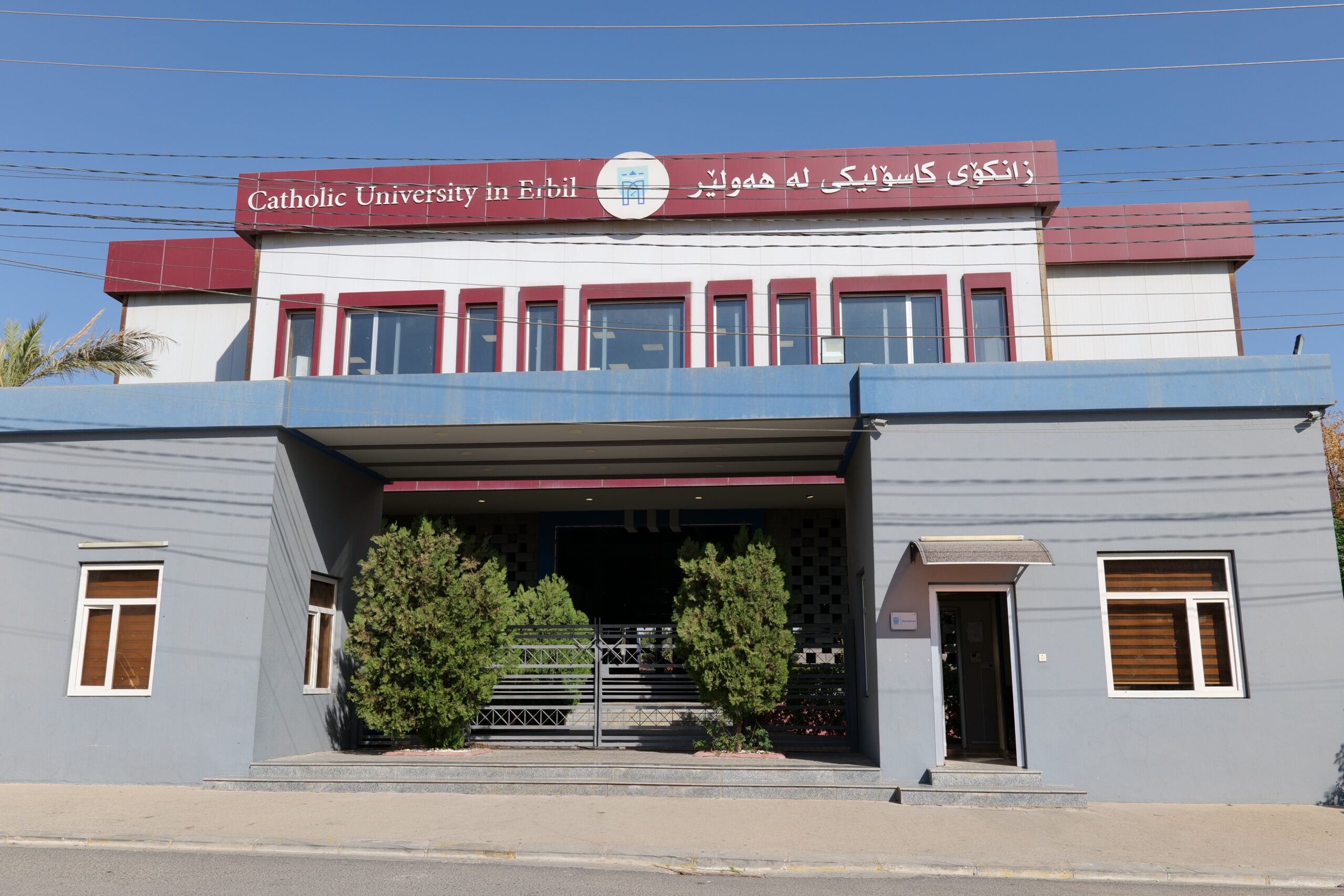 Front view of the Catholic University in Erbil, showcasing modern architecture and landscaped entrance.