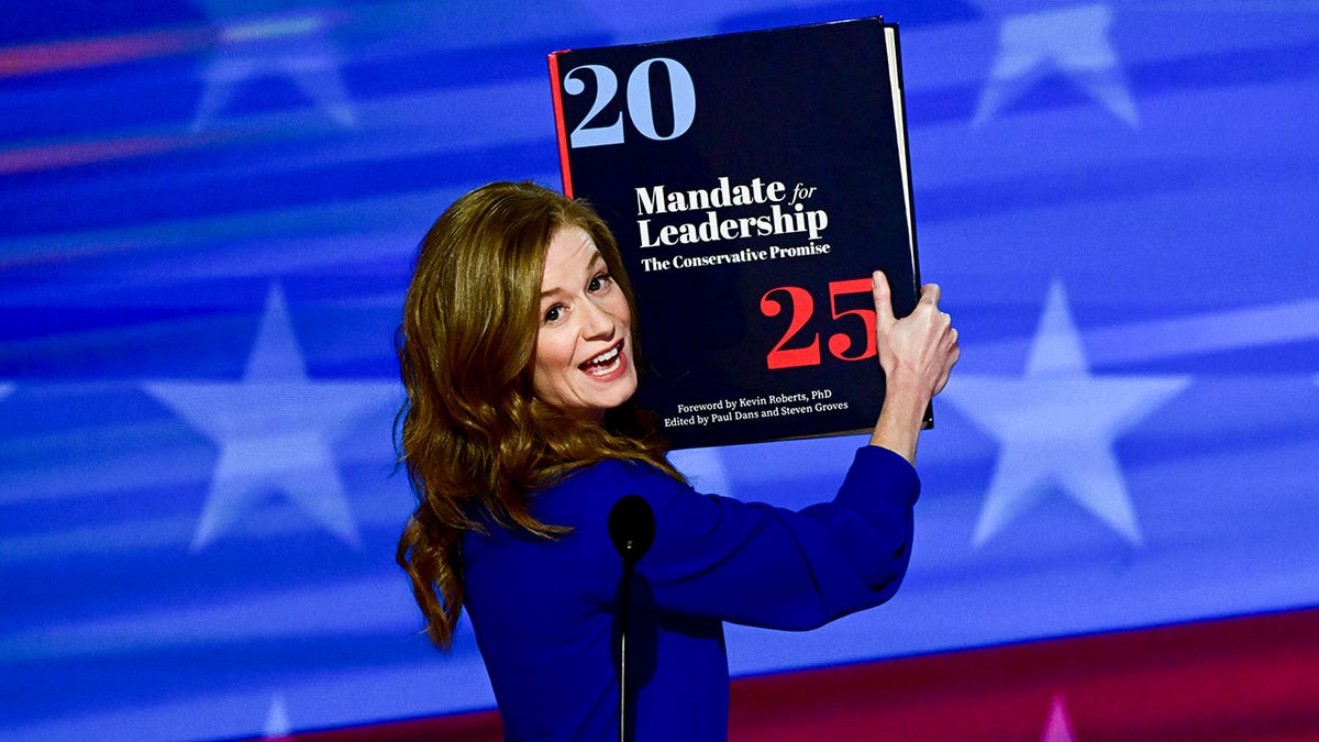 Mallory McMorrow holds up Project 2025 at the DNC