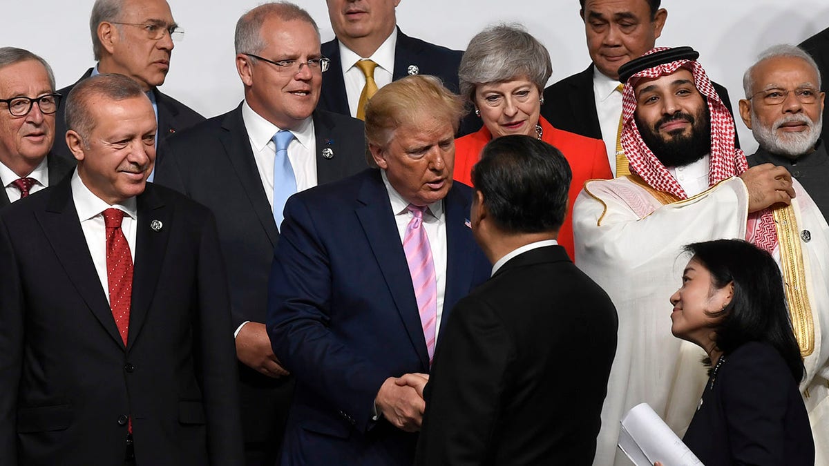 President Donald Trump, center, shakes hands with Chinese President Xi Jinping, as they gather for a group photo at the G-20 summit in Osaka, Japan, Friday, June 28, 2019. (AP Photo/Susan Walsh)