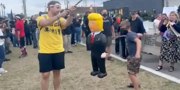 Child at 'No Kings' protest stabs at Trump piñata