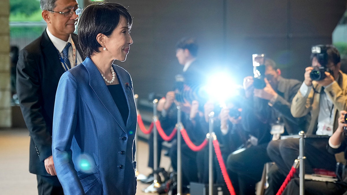 Sanae Takaichi walks past photographers.