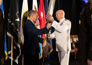 U.S. Air Force Gen. Dan C. Caine, chairman of the Joint Chiefs of Staff, passes the colors to U.S. Navy Adm. Frank “Mitch” Bradley, incoming commander, U.S. Special Operations Command, during a change of command ceremony in Tampa, Florida, October 3, 2025.