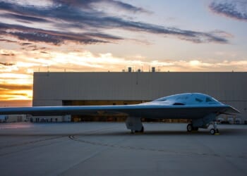 A B-21 Raider outside a manufacturing plant.