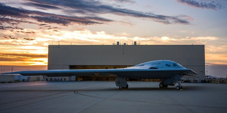 A B-21 Raider outside a manufacturing plant.