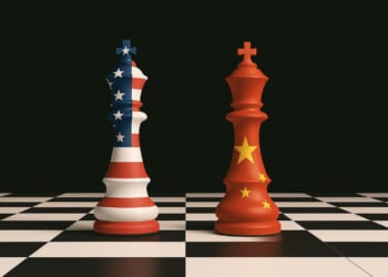 Chess pieces representing the United States and China stand on a chessboard, symbolizing strategic competition between the two nations.