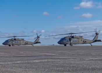 Two Black Hawk helicopters at an airport.