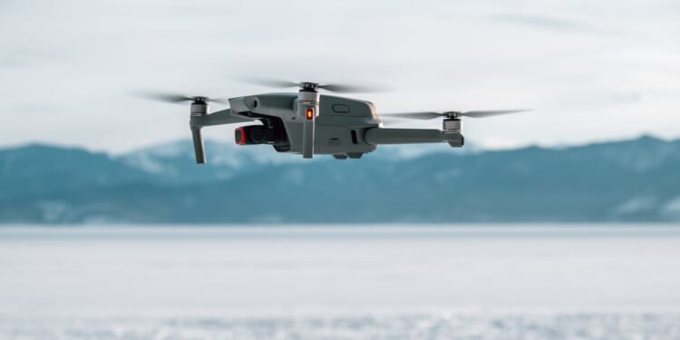 A drone against a snowy mountain backdrop.