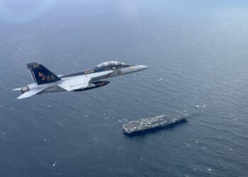 An F/A-18F Super Hornet, attached to Strike Fighter Squadron 213, piloted by Lt. Cmdr. Chris Kapuschansky with Gen. Sir Gwyn Jenkins, First Sea Lord and Chief of the Naval Staff, Royal Navy, embarked, flies over the world's largest aircraft carrier, USS Gerald R. Ford (CVN 78), in the North Sea, Sept. 26, 2025.
