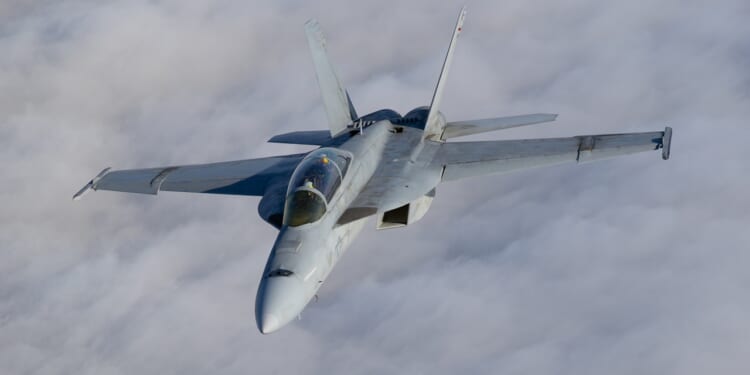 Top view of a FA-18F Super Hornet over clouds.