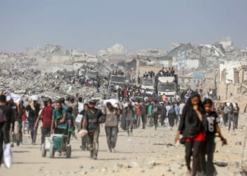 Civilians in Gaza carry humanitarian aid amid the ruins.