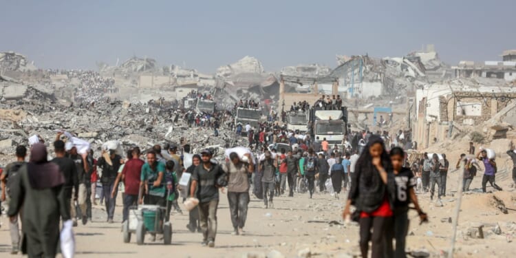 Civilians in Gaza carry humanitarian aid amid the ruins.