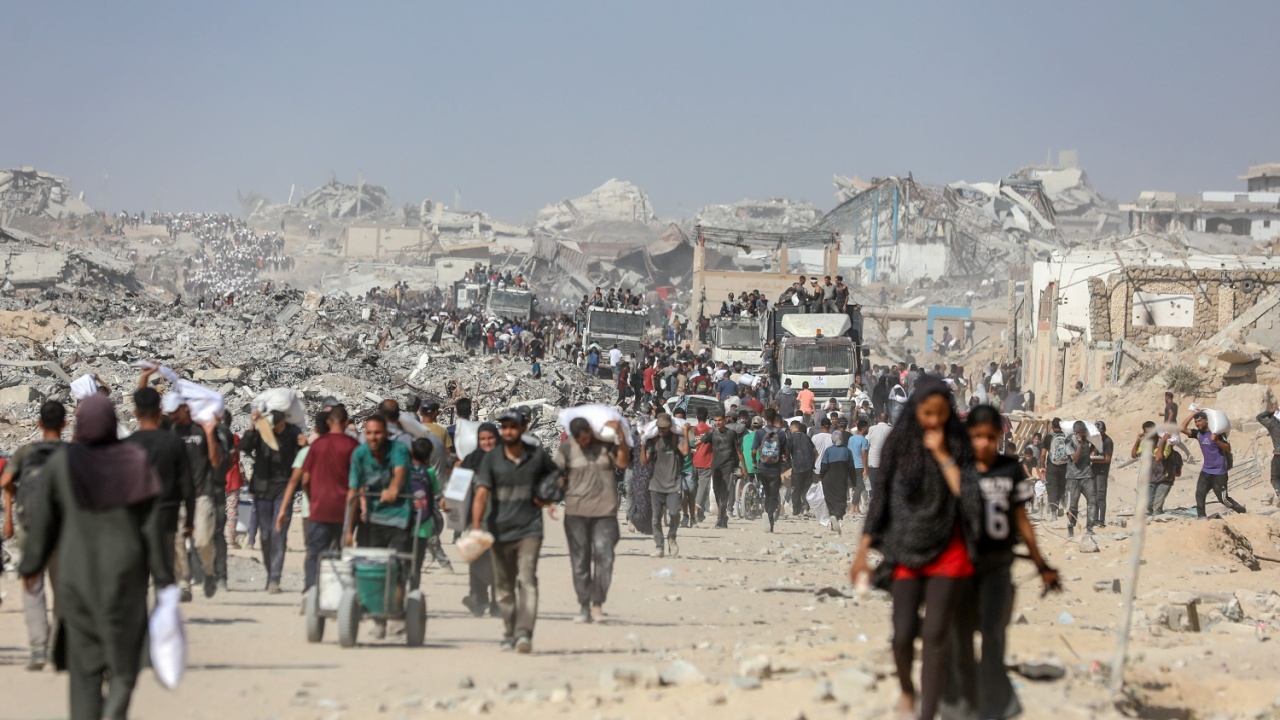 Civilians in Gaza carry humanitarian aid amid the ruins.