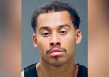 Mugshot of a young man with short hair and a mustache, displaying a serious expression against a neutral background.