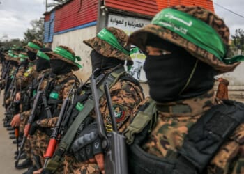 Hamas troops oversee the return of hostages to Israel.