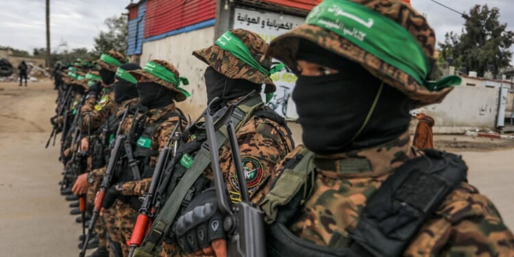 Hamas troops oversee the return of hostages to Israel.