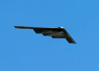 A Northrop Grumman B-2 Spirit Stealth bomber flies overhead at the dedication of the Air Force Memorial in Arlington Virginia.
