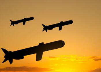 A group of Tomahawk missiles fired against a twilight background.