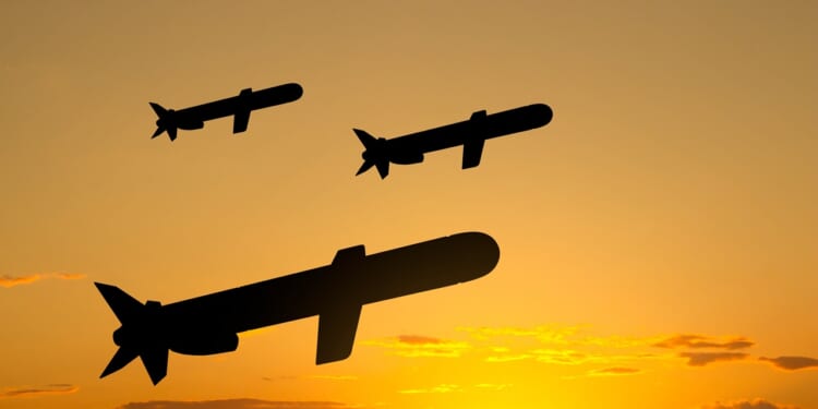 A group of Tomahawk missiles fired against a twilight background.