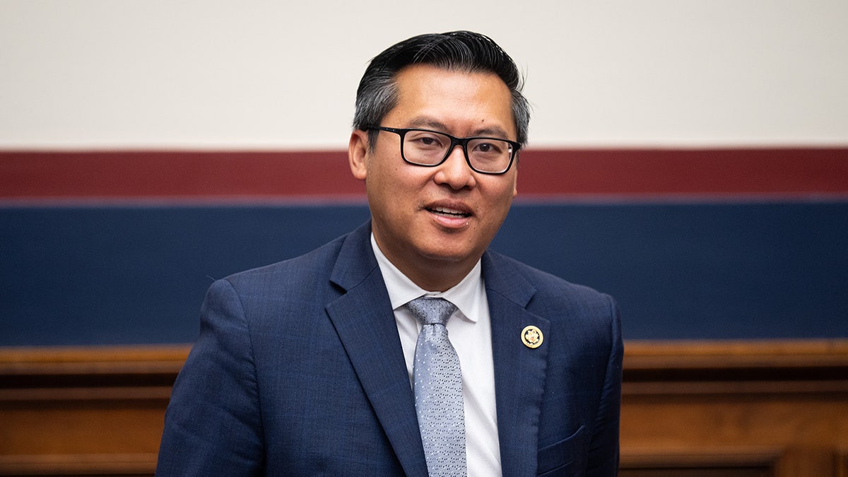 Vince Fong smiles at camera in hallway