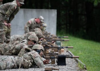 A group of soldiers firing the M250 machine gun.