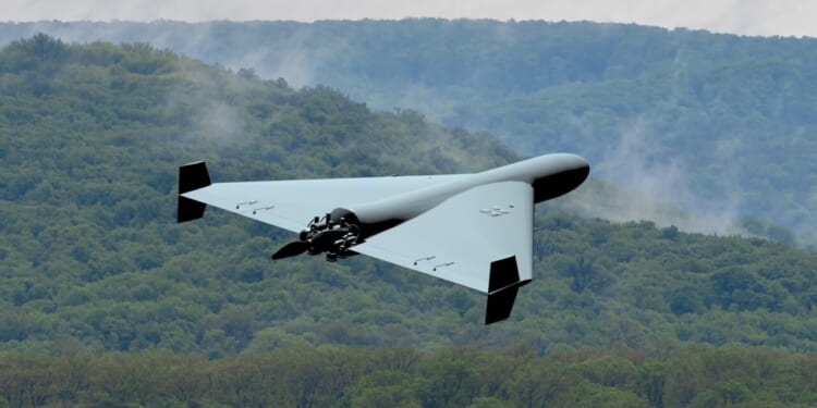 Military kamikaze drone flying over forest in the clouds, Combat drone in the sky, war in Ukraine.
