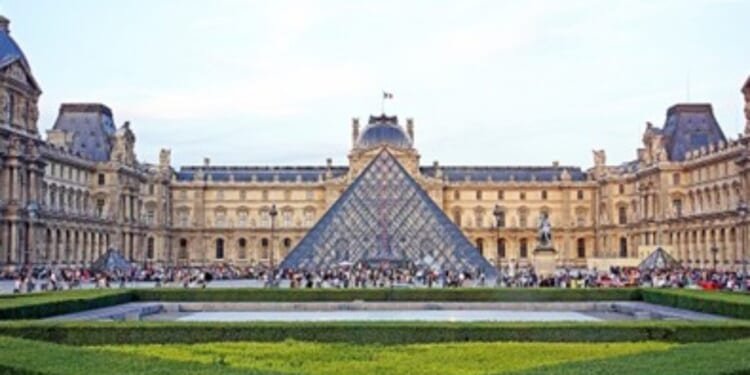 Louvre Museum with iconic glass pyramid, surrounded by historic architecture and lush gardens, attracting numerous visitors in Paris, France.